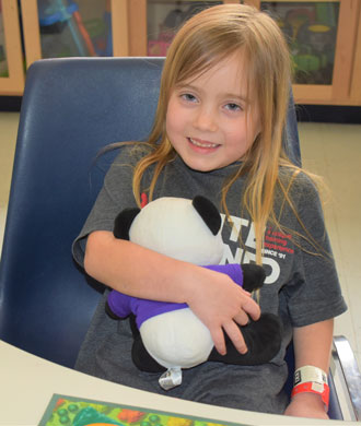 A young Kennedy Krieger patient holds a stuffed panda.