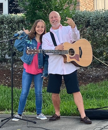 Lola and Mitch posing with a microphone and guitar