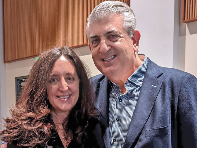 Portrait photo of a woman and a man, both wearing blazers.