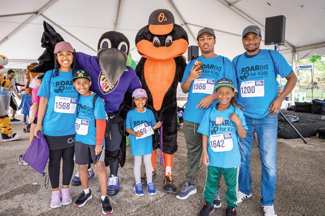 A family with the Baltimore Orioles and Baltimore Ravens mascots at ROAR for Kids