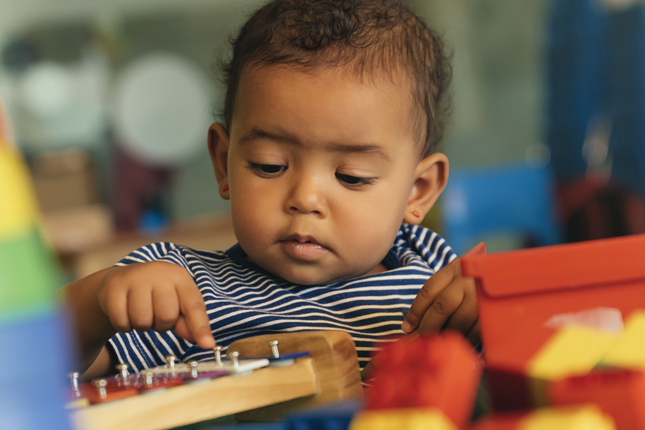 A toddler playing with blocks.