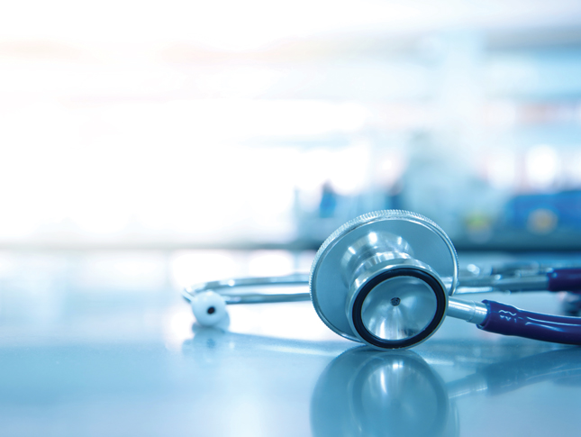 A stethoscope for sits on medical laboratory table. The background of the image is faded.