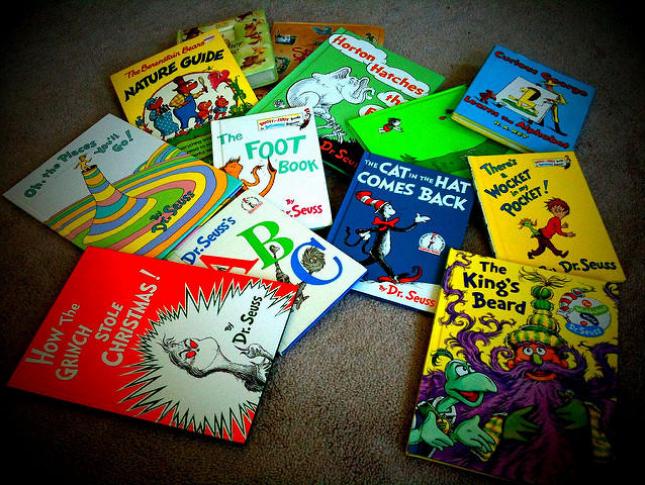 An assortment of Dr. Seuss books sit atop a carpet