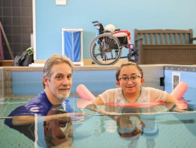 A photo of Shannon in an aquatic therapy pool with her physical therapist, Chris Joseph