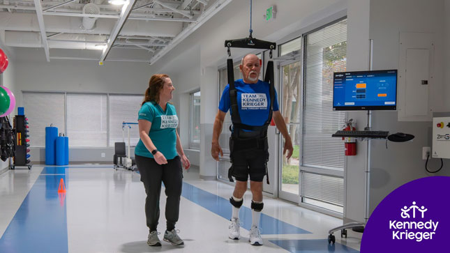 An International Center for Spinal Injury does partial weight-support walking therapy as a therapist walks beside him.