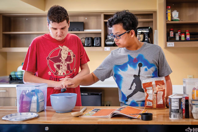 Two students stir ingredients in a bowl during a life skills class.