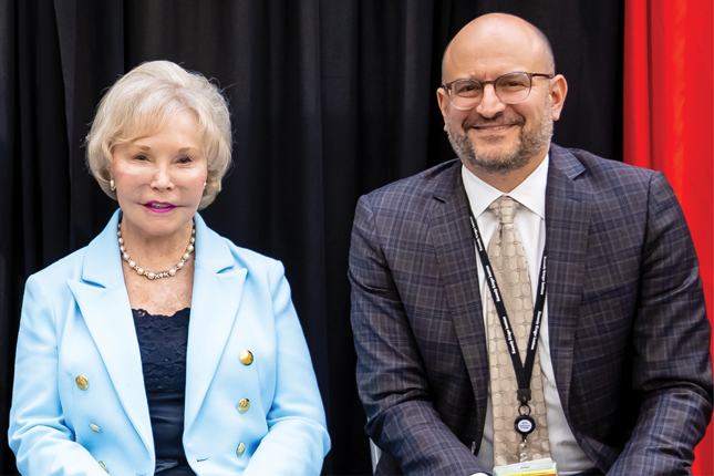 Drs. Nancy Grasmick and Brad Schlaggar sit next to each other on a stage.