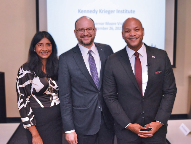 Posed photo of a woman and two men. All three are smiling and wearing business attire.