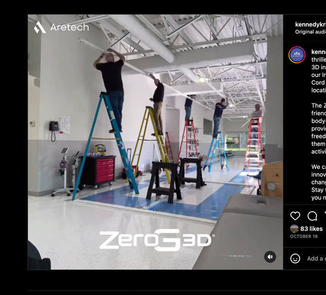 Five adults stand atop colorful ladders in an open interior space while adjusting ceiling apparatus.