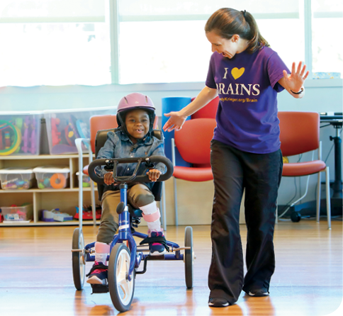 A photo of Journee with physical therapist Alissa Marzetti during a therapy appointment a year after Journee's surgery.