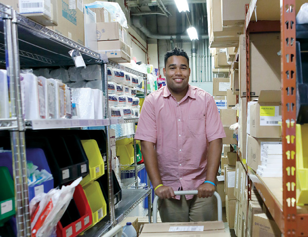 A photo of John Perry, an inventory technician at Kennedy Krieger. His job entails stocking, packing, and delivering supplies to various Institute departments.