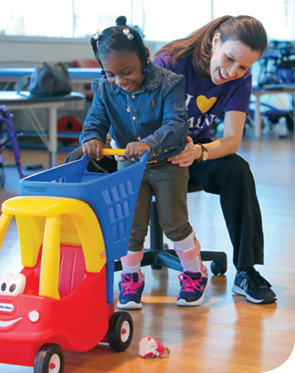 A photo of Journee with physical therapist Alissa Marzetti during a therapy appointment a year after Journee's surgery.