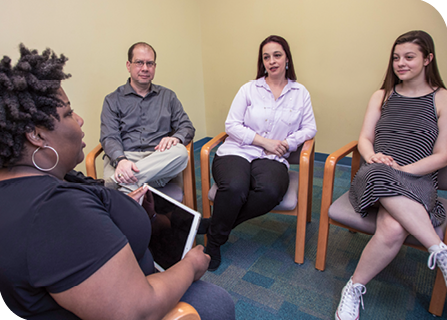 Dr. Christi Culpepper (left) talks with Addison (right) and Addison’s parents, Todd and Amanda (center), during a therapy session.