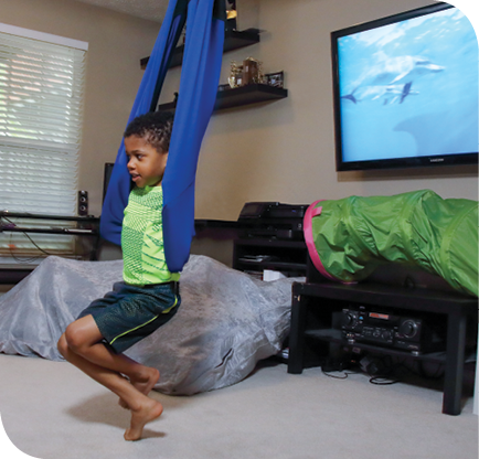 Dale’s father created a sensory circuit for Dale to use at home. Here, Dale plays with a therapy swing.