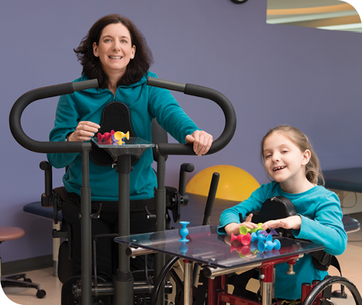 Standers allow Caryn and Caetlyn to stand upright as part of physical therapy.