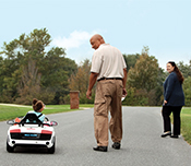 Sophia goes for a drive while her parents walk alongside