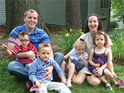 The family poses for a photo at home