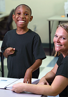 Mikey and his teacher, Gabriela Bandi, work on a matching activity at a desk in Bandi’s classroom at Kennedy Krieger High School.