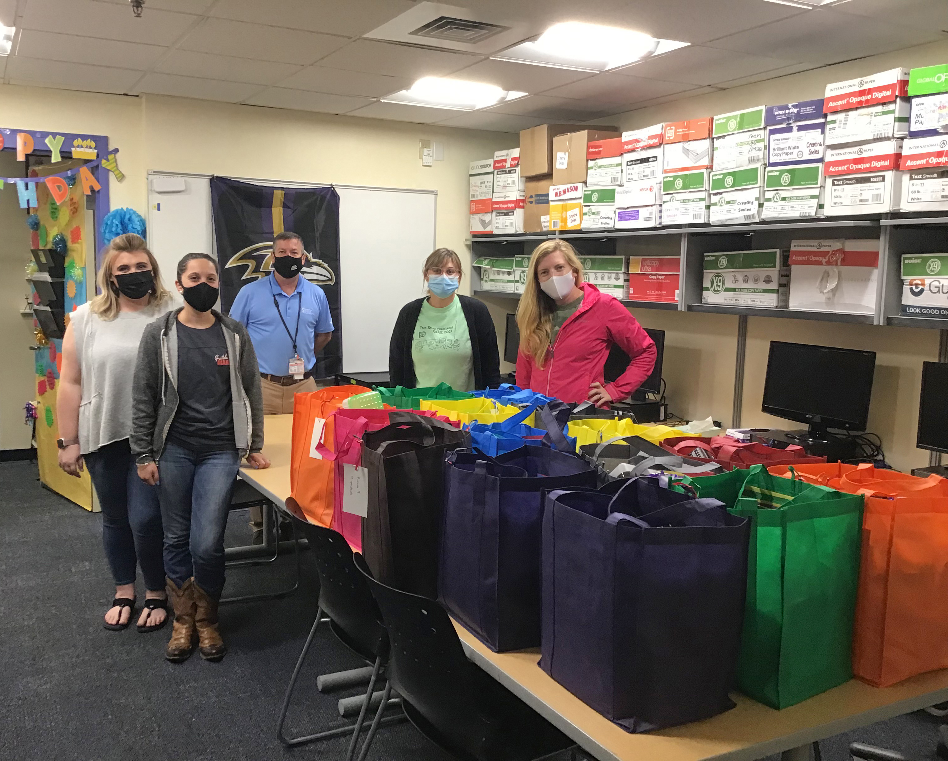 Kennedy Krieger staff members stand behind bags that were packed as part of an Act for Kindness. 