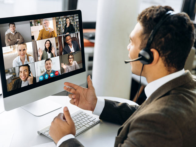 A man talks during a webinar. Nine participants are seen on his monitor.