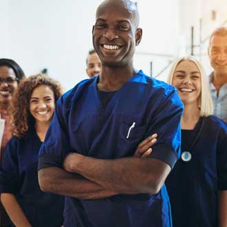 A team of doctors and nurses stand for a photo. 