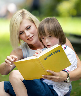 A woman reads a book to a child. 