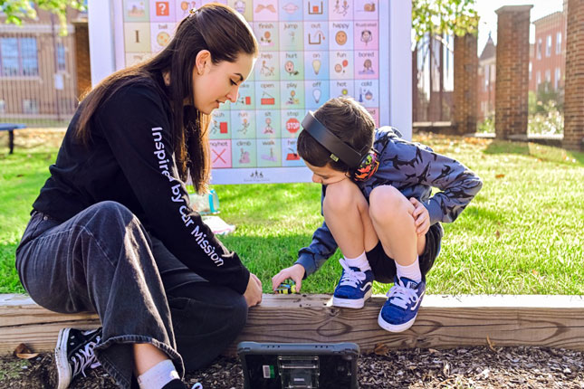 A student and therapist in the playground of Fairmount Campus.