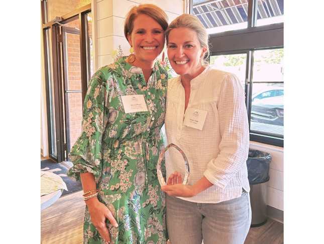 Dulany Dent holds Lainy Lebow Sachs award. She stands to the right, with Allyson Peters, a Kennedy Krieger Foundation employee, standing to her left.