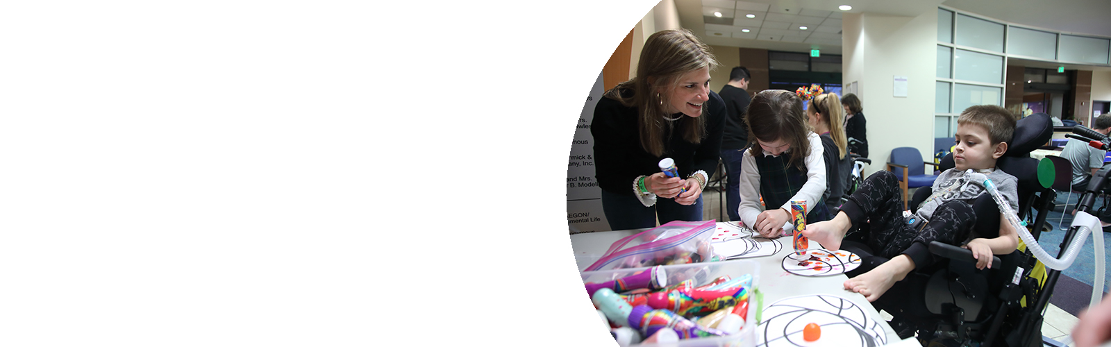 A WIN volunteer helps two kids with an arts and crafts project.