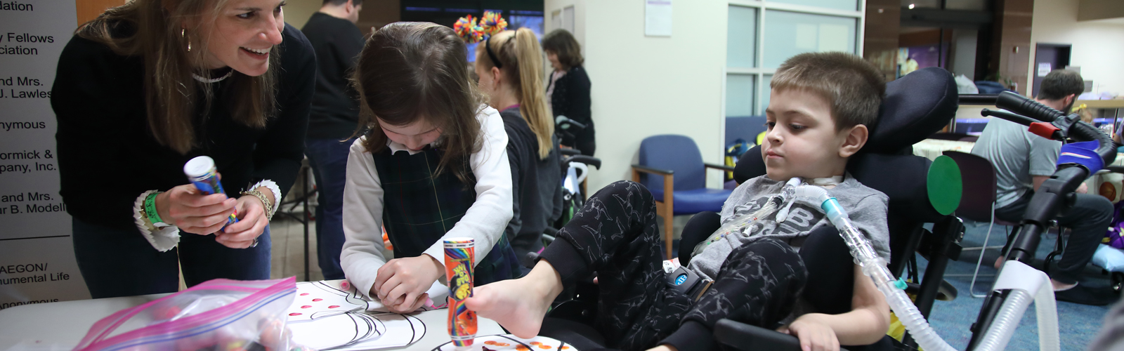 A WIN volunteer helps two kids with an arts and crafts project.