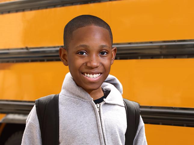 Mikey Standing in front of a school bus