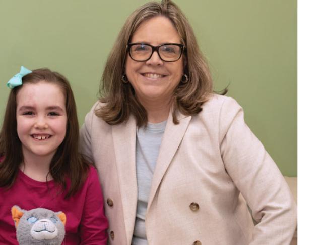 A young girl with Sturge-Weber syndrome and Dr. Anne Comi smile during an appointment at Kennedy Krieger.