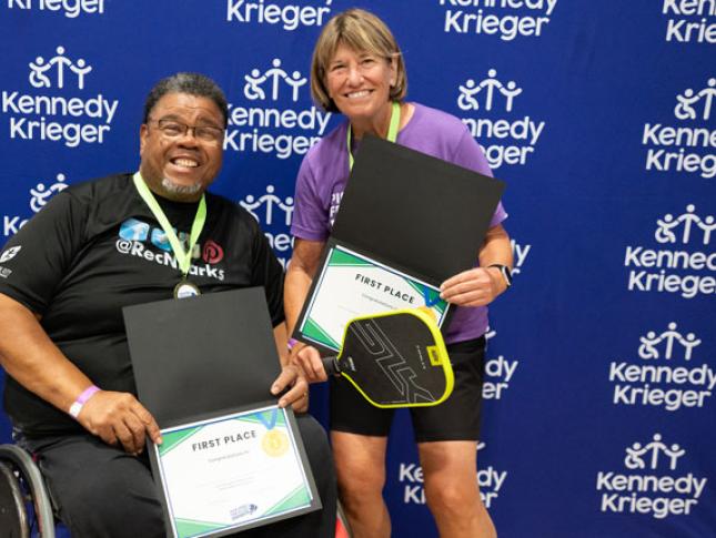 Pickleball for All winners smile while holding first place certificates.