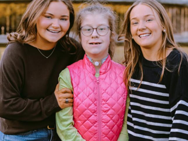 Mackie, Emmy, and Molly smile in their family's backyard.