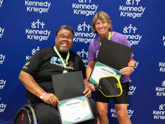 Pickleball for All winners smile while holding first place certificates.