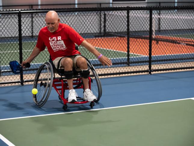 An adaptive athlete plays pickleball.