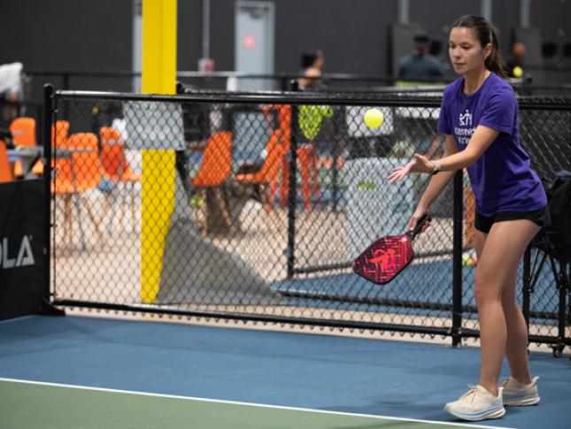 A pickleball for all participant prepares her serve.