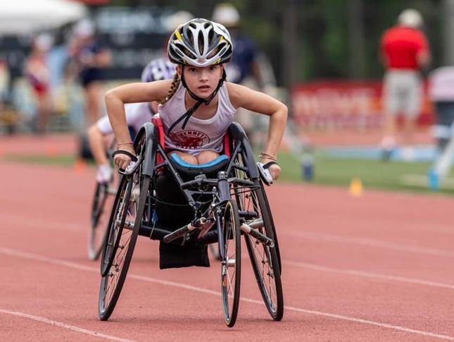 A young girl participates in an adaptive track and field race.