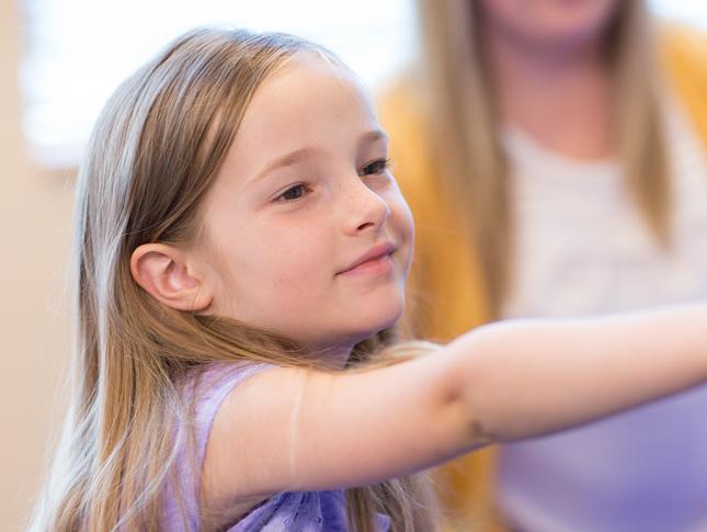 A young girl sits in a classroom.