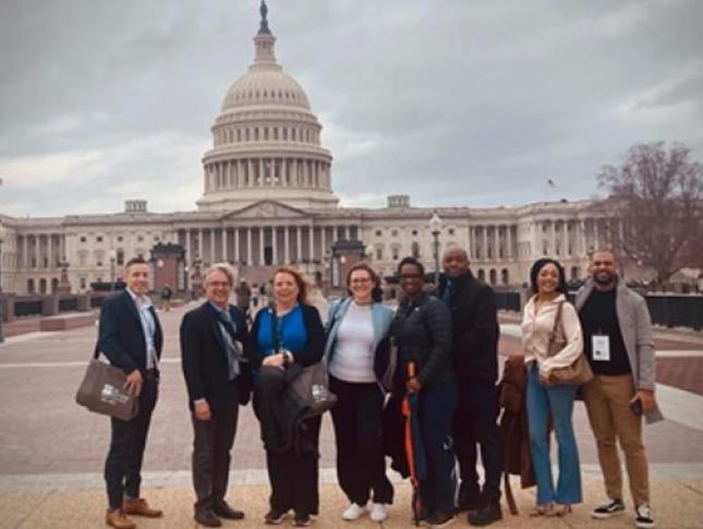 A group of people stand outside the U.S. Capitol building.