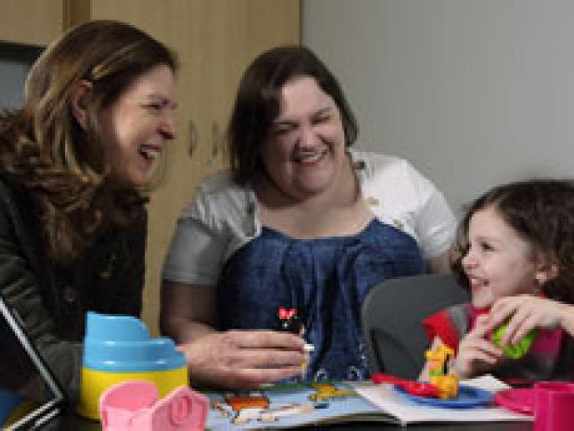 A little girl smiles while interacting with her care team at CASSI.