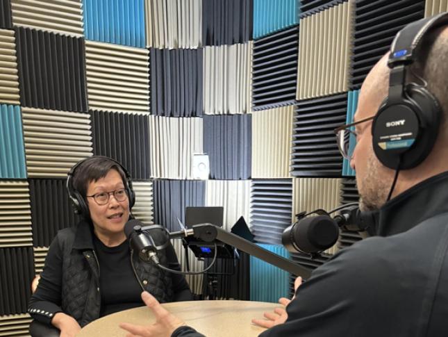 Drs. Brad Schlaggar and Dr. Theresa Nguyen sit in a studio recording a podcast episode.