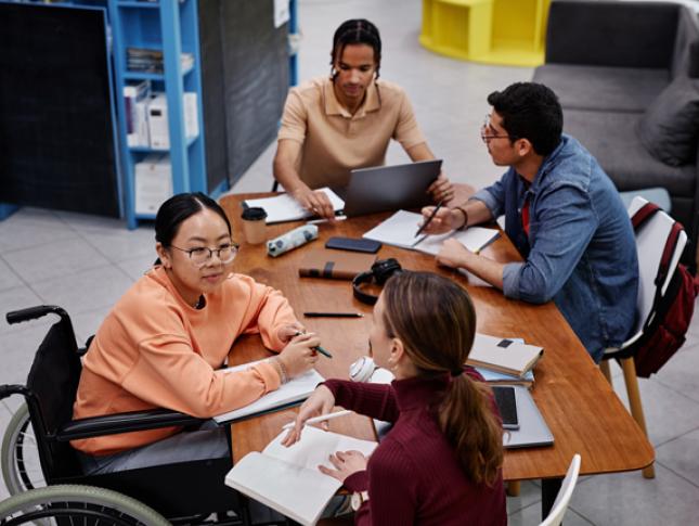 Four people sit around an accessible table.