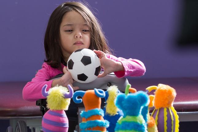 Sanayah holds a toy soccer ball