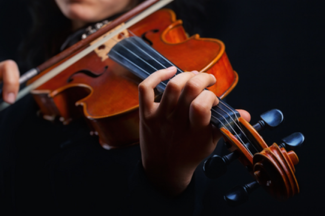 A closeup image of a violinist playing the violin. 