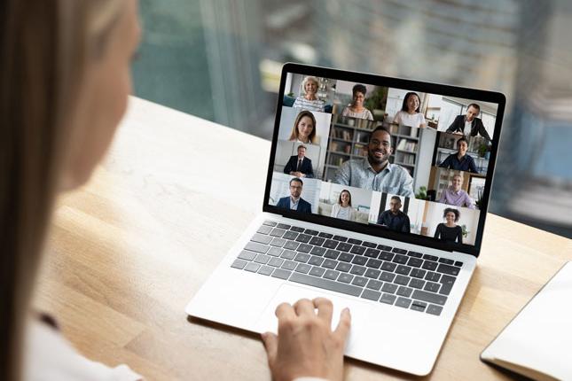 Close up back view of woman participating in online video call with colleagues.