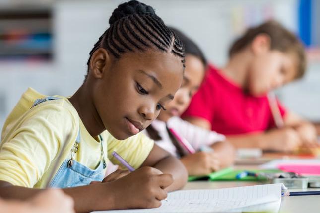 Children writing notes in classroom