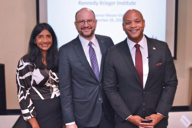 Posed photo of a woman and two men. All three are smiling and wearing business attire.