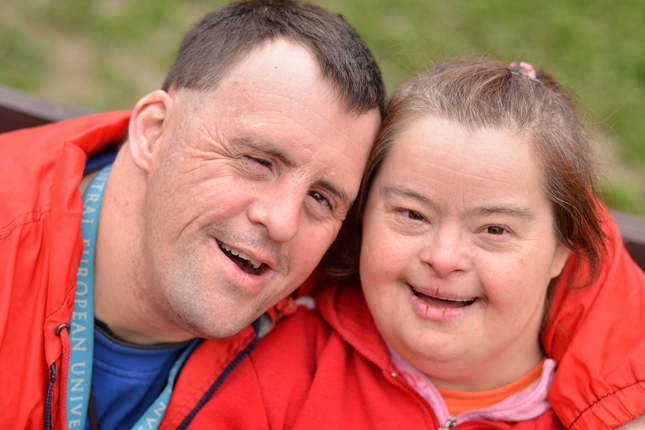 Two adults with Down syndrome wearing athletic apparel.