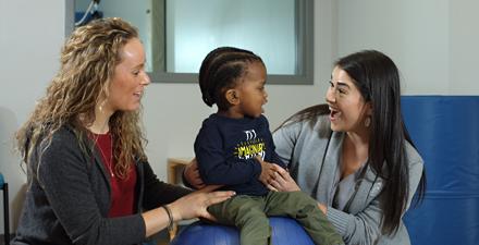 A patient sits between two therapists